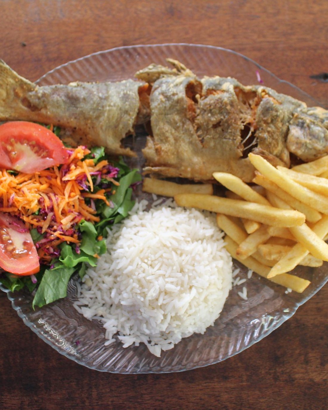 Trucha servida con arroz, ensalada y papas