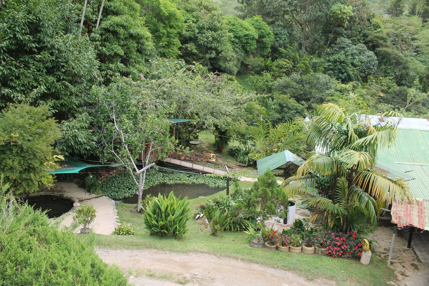 Vista del truchero con sus lagos, el jardín y la montaña alrededor